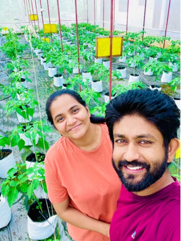 Hotzy Foods founders in a greenhouse with chili plants